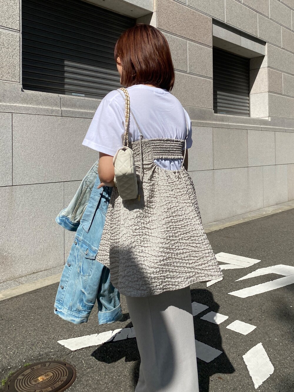 グレー系のキャミソール、ベージュ系のスカート、ブルー系のジャケット/アウターを着用したレディースの春コーディネートの5枚目の写真