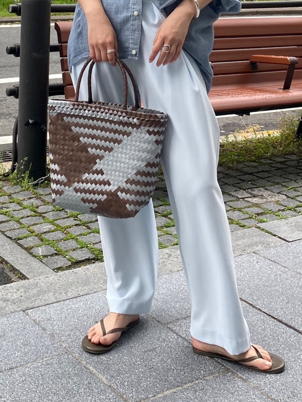 ブルー系のシャツ/ブラウス、ブラウン系のタンクトップ、ブルー系のスラックスを着用したレディースの春コーディネートの5枚目の写真