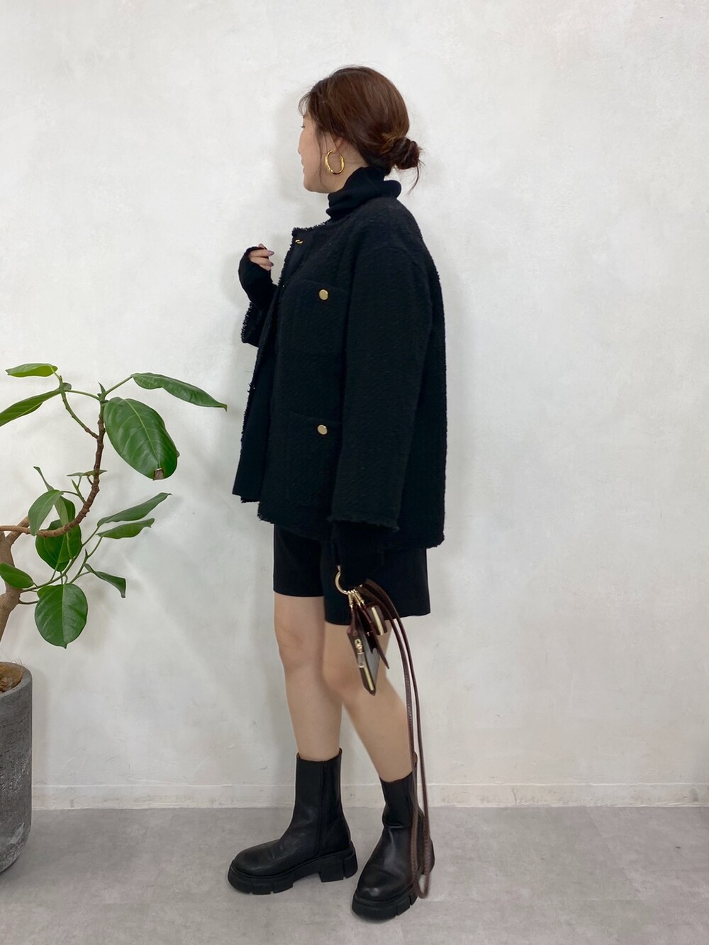 ブラック系のノーカラージャケット、ブラック系のニット/セーター、ブラック系のブーツを着用したレディースの秋コーディネートの4枚目の写真