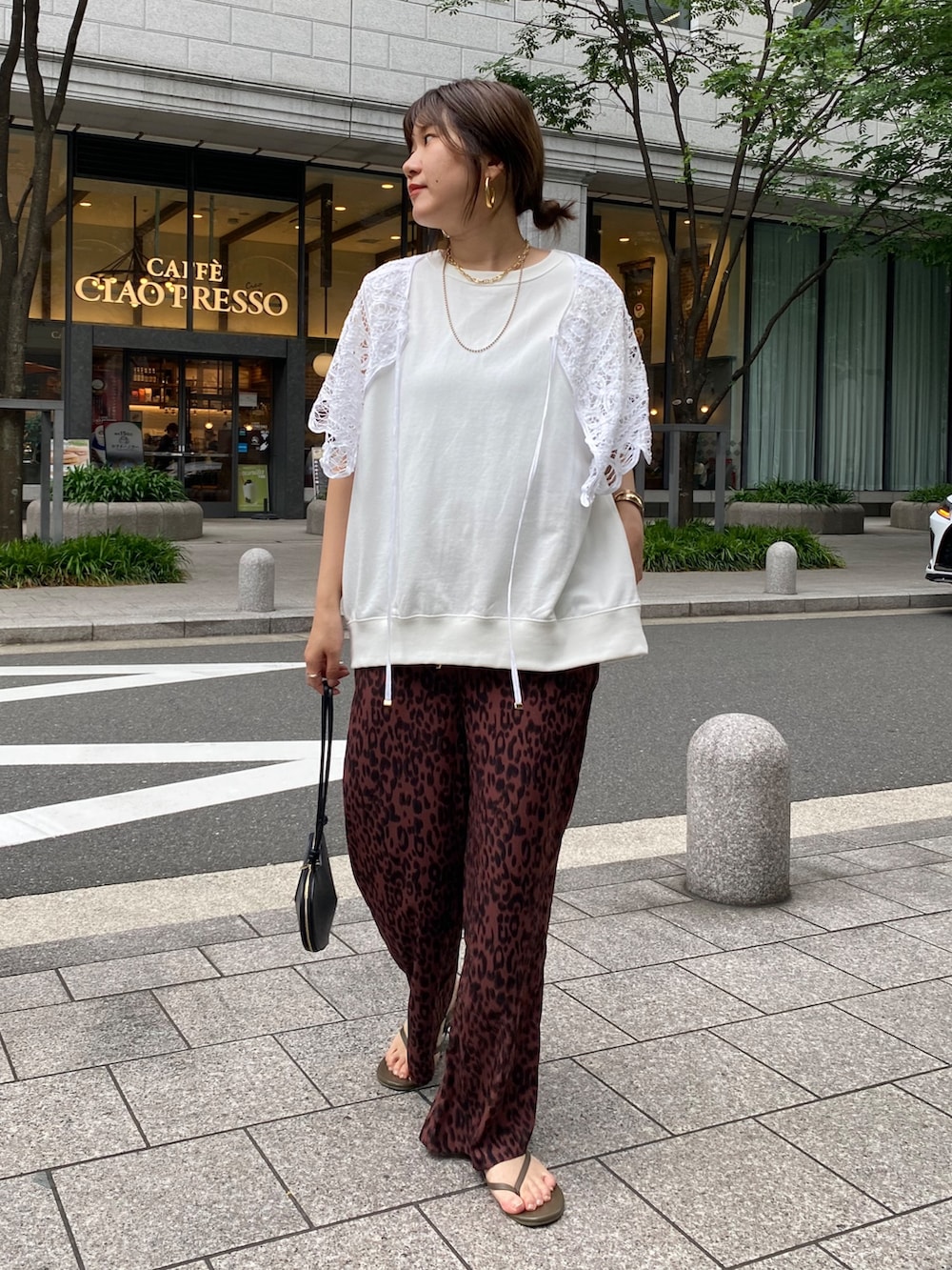 ホワイト系のスウェット、レッド系のその他パンツ、ブラック系のショルダーバッグを着用したレディースの夏コーディネートの2枚目の写真