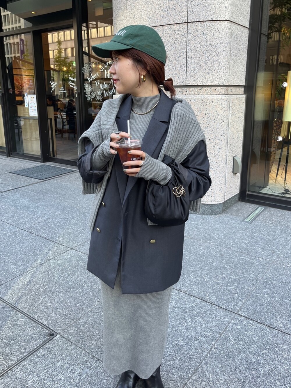 グレー系のテーラードジャケット、ベージュ系のワンピース、ブラック系のブーツを着用したレディースの冬コーディネートの3枚目の写真