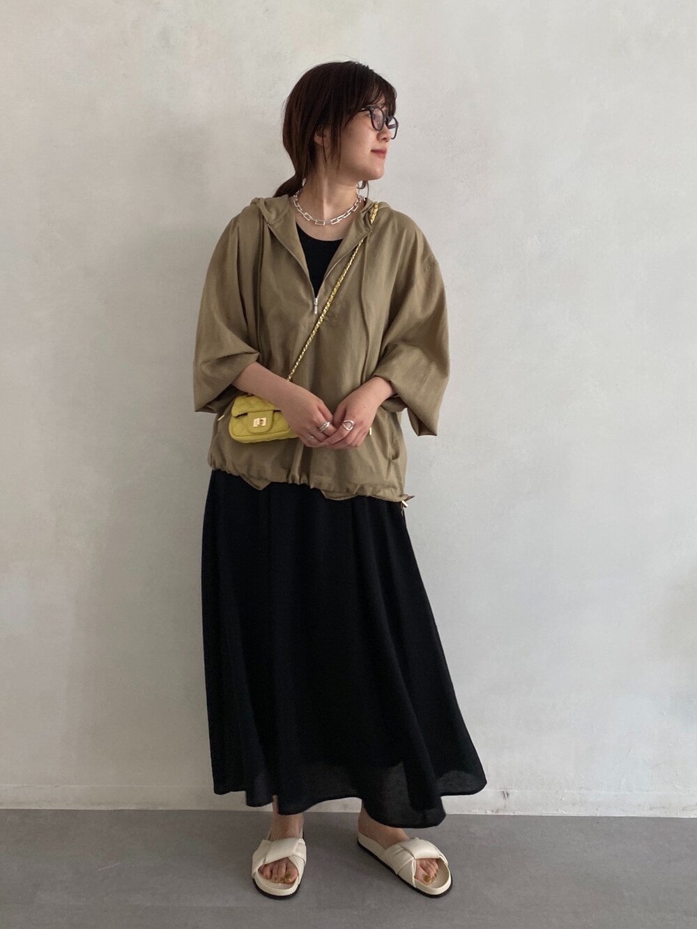 ベージュ系のシャツ/ブラウス、イエロー系のショルダーバッグ、ブラック系のワンピースを着用したレディースの夏コーディネートの4枚目の写真