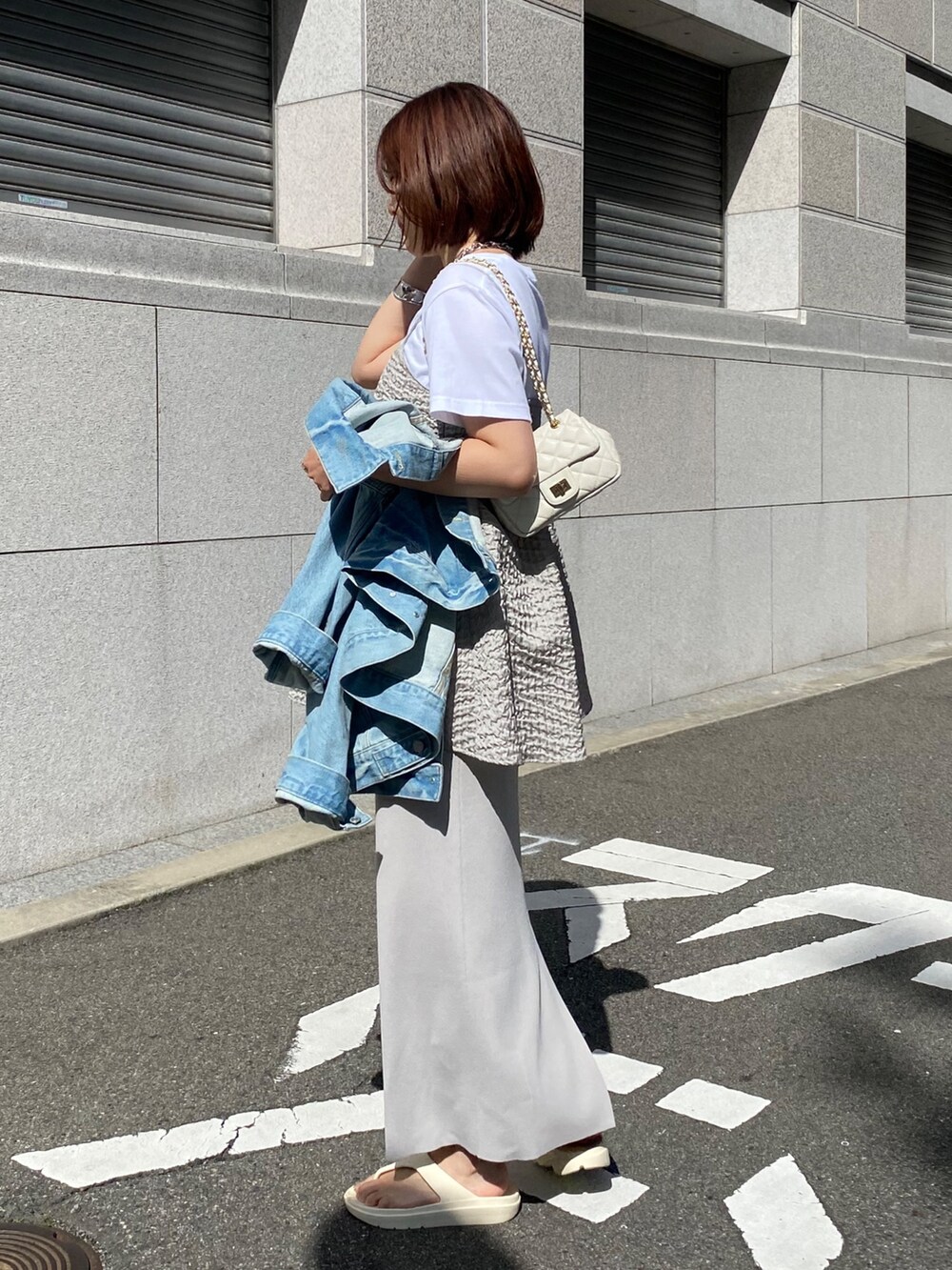 グレー系のキャミソール、ベージュ系のスカート、ブルー系のジャケット/アウターを着用したレディースの春コーディネートの6枚目の写真