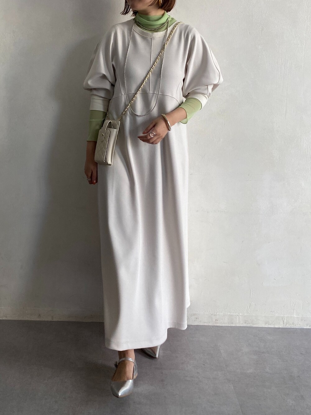 グリーン系のTシャツ/カットソー、ホワイト系のショルダーバッグ、ホワイト系のワンピースを着用したレディースの冬コーディネートの5枚目の写真