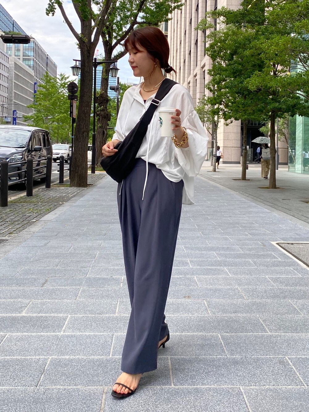 ホワイト系のシャツ/ブラウス、グレー系のスラックス、シルバー系のサンダルを着用したレディースの夏コーディネートの5枚目の写真