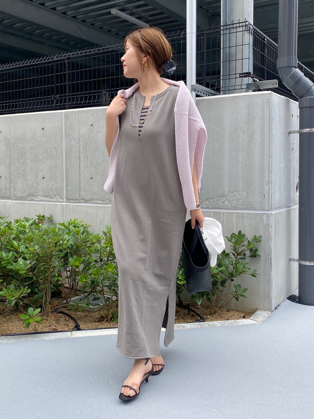 ホワイト系のワンピース、ブラック系のかごバッグ、ブラック系のニット/セーターを着用したレディースの春コーディネートの9枚目の写真