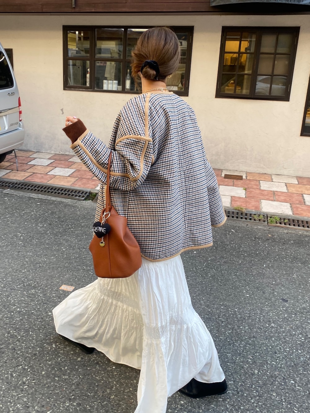 ベージュ系のその他アウター、ブラウン系のニット/セーター、ホワイト系のスカートを着用したレディースの冬コーディネートの2枚目の写真