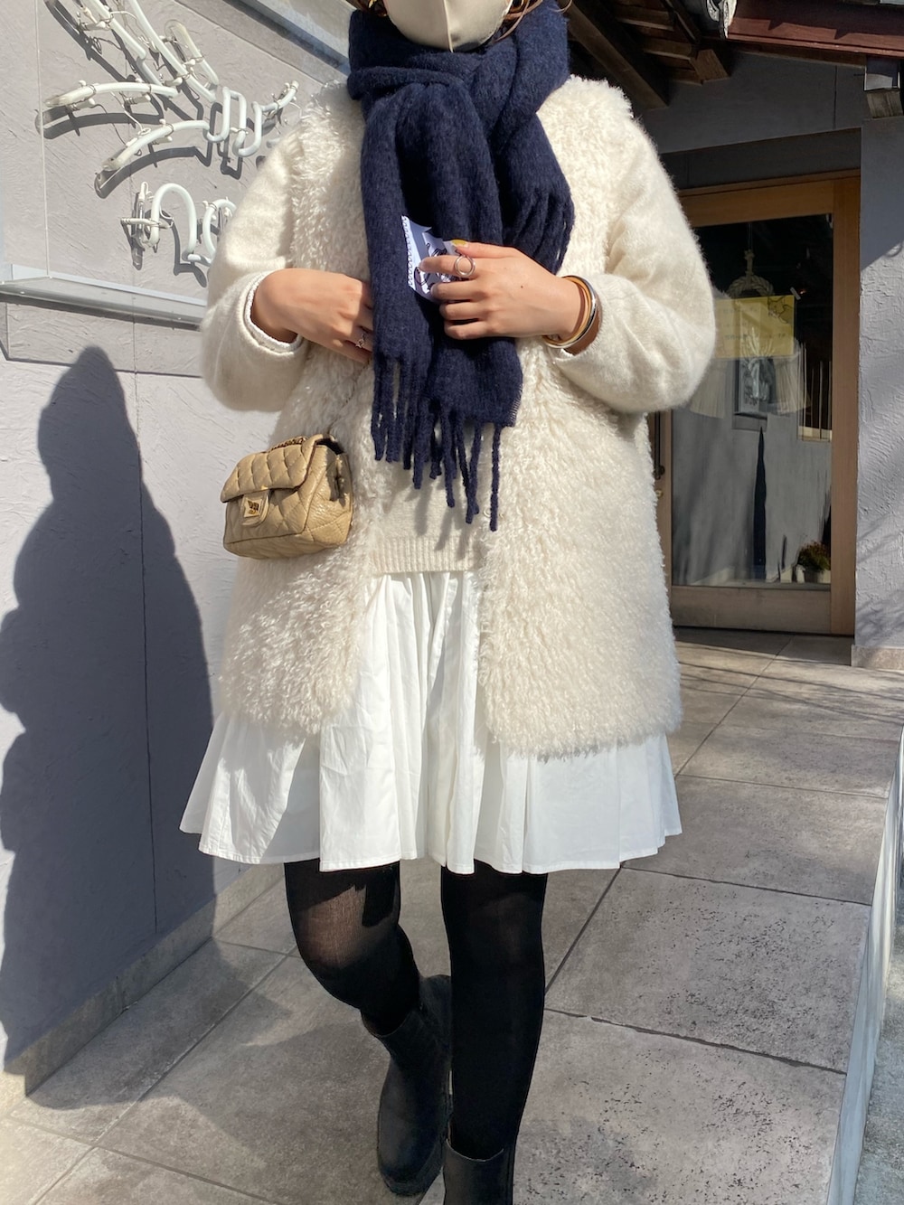 ホワイト系のベスト、ホワイト系のニット/セーター、ホワイト系のシャツ/ブラウスを着用したレディースの冬コーディネートの5枚目の写真