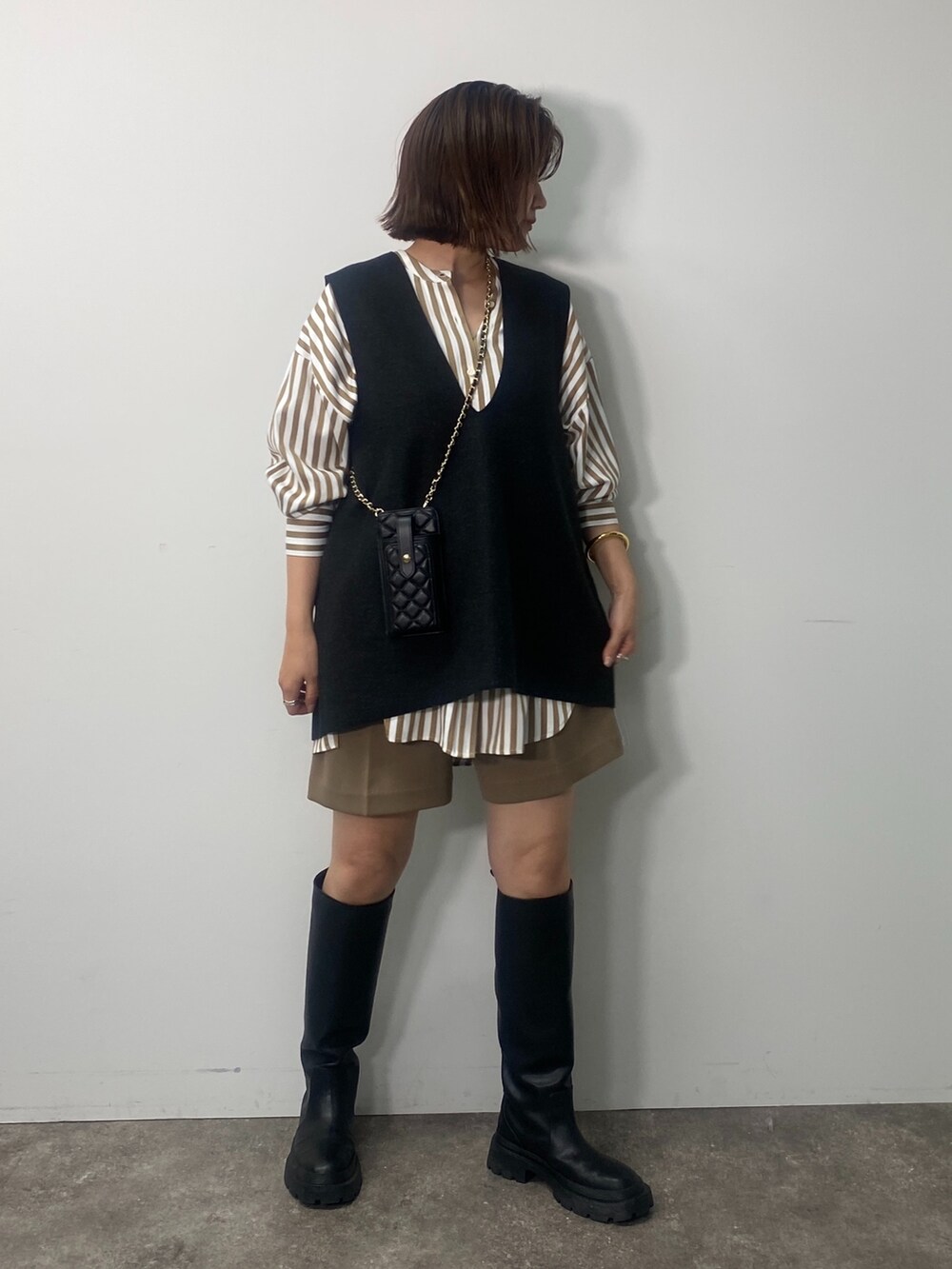 グレー系のベスト、ベージュ系のシャツ/ブラウス、イエロー系のその他パンツを着用したレディースの秋コーディネートの4枚目の写真