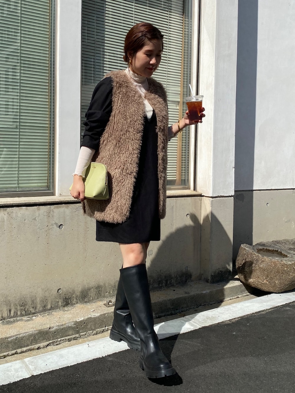 ベージュ系のベスト、ブラック系のワンピース、ブラック系のその他シューズを着用したレディースの秋コーディネートの3枚目の写真