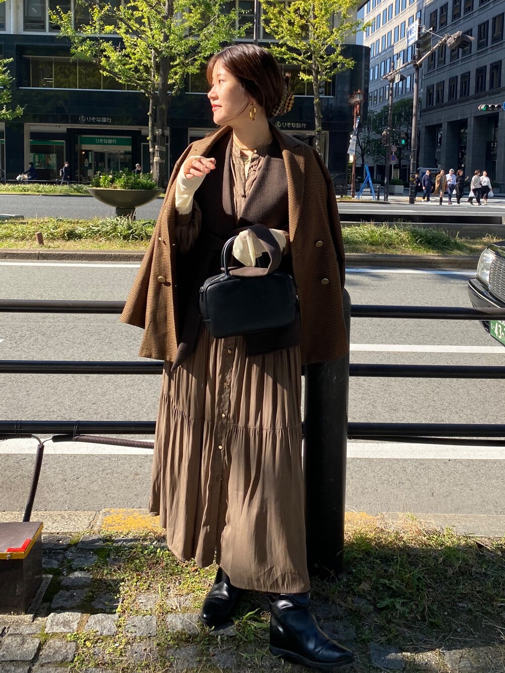 ブラウン系のベスト、ブラウン系のテーラードジャケット、ブラウン系のワンピースを着用したレディースの冬コーディネートの4枚目の写真