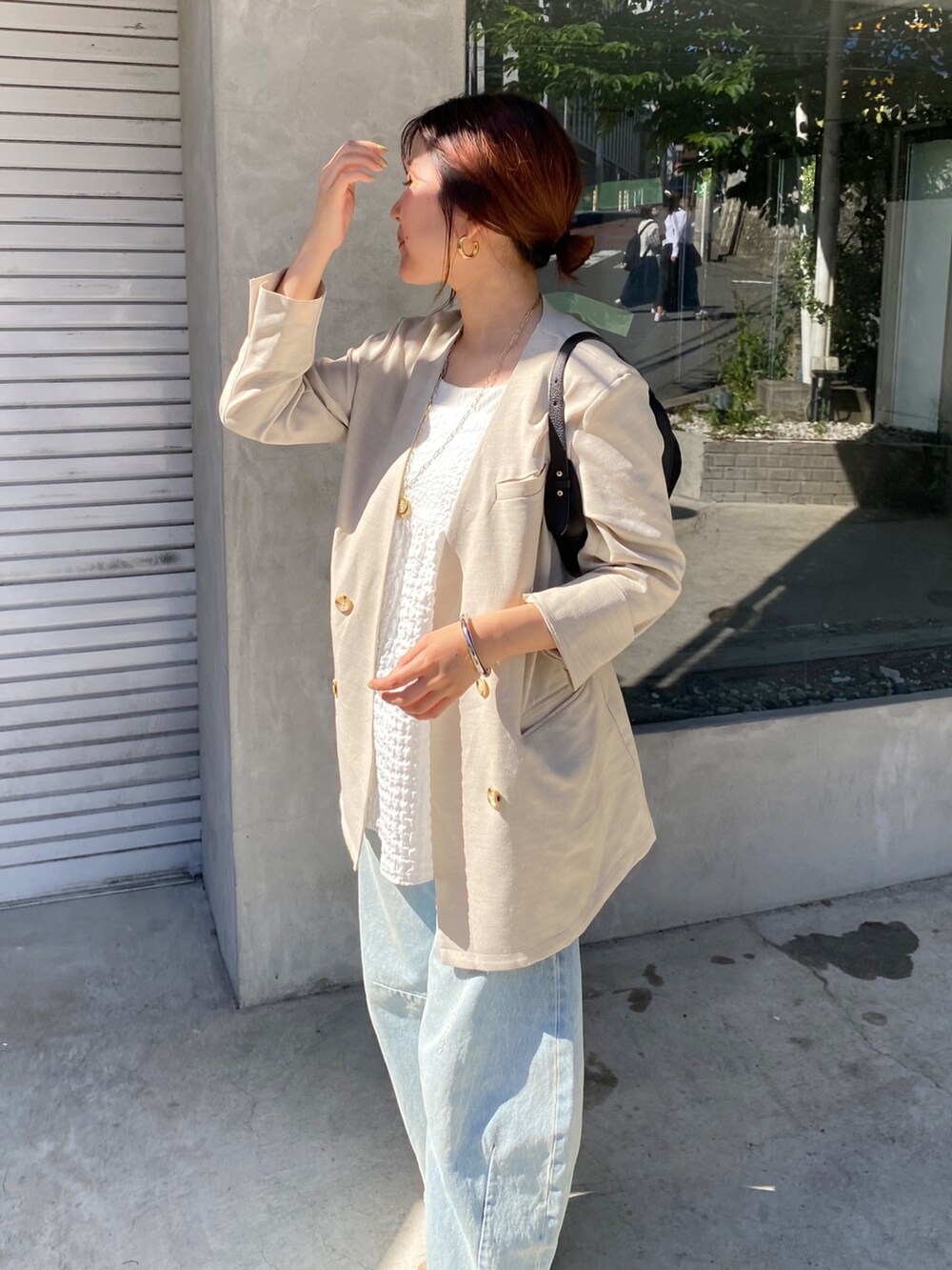 ホワイト系のキャミソール、ブルー系のデニムパンツ、ブラック系のショルダーバッグを着用したレディースの夏コーディネートの4枚目の写真