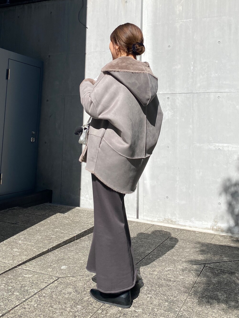 ブルー系のニット/セーター、ブルー系のTシャツ/カットソー、グレー系のムートンコートを着用したレディースの冬コーディネートの4枚目の写真