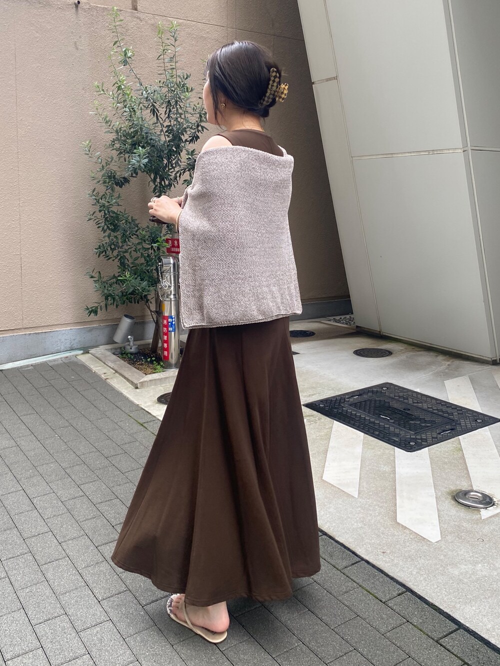 ブラウン系のワンピース、ベージュ系のニット/セーター、ブラウン系のショルダーバッグを着用したレディースの夏コーディネートの2枚目の写真