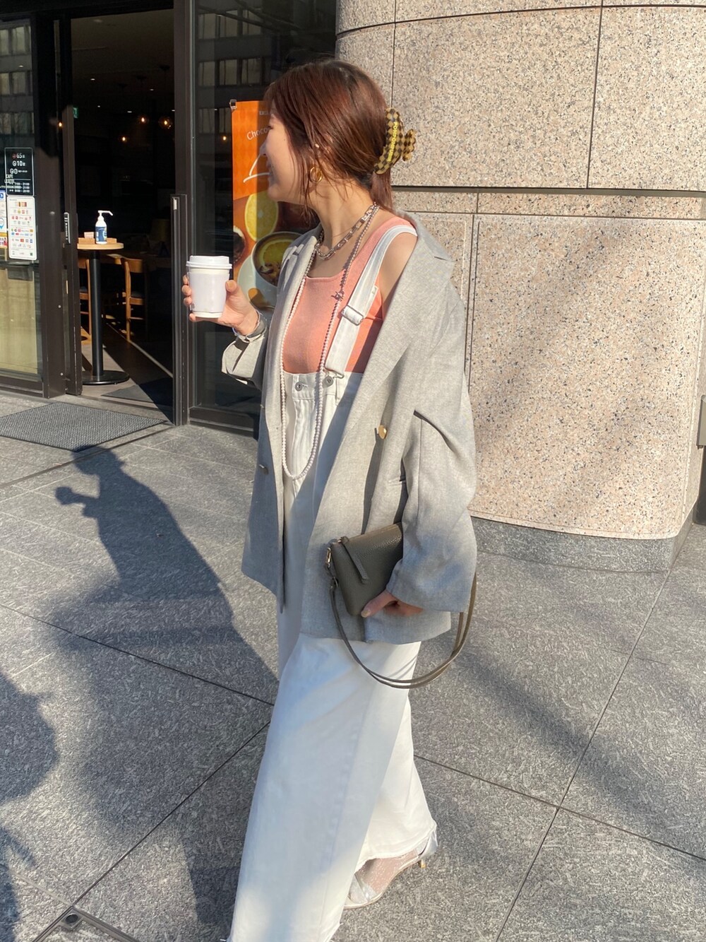 ピンク系のタンクトップ、ホワイト系のサロペット/オーバーオール、グレー系のテーラードジャケットを着用したレディースの春コーディネートの4枚目の写真