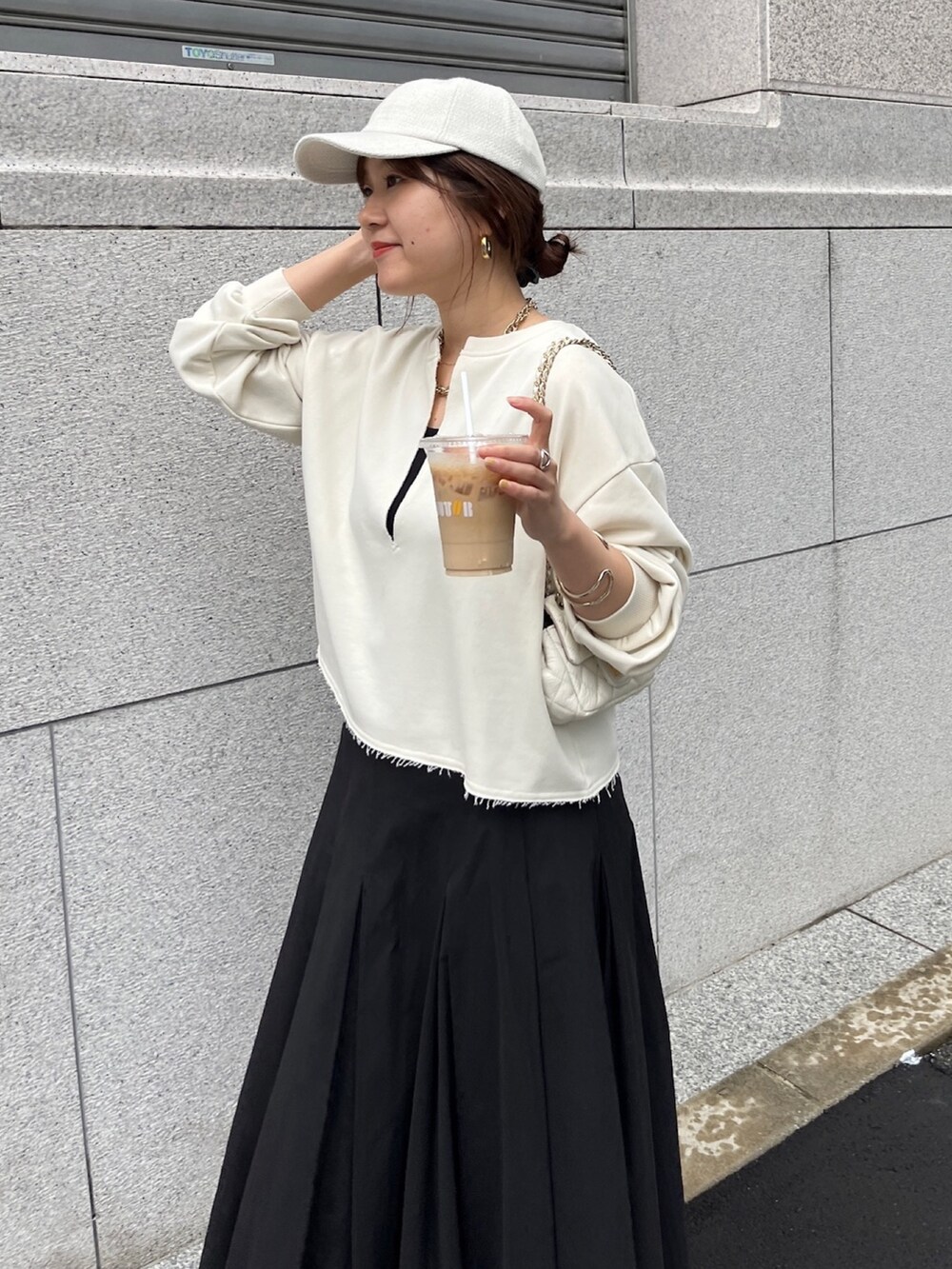 ベージュ系のスウェット、ブラック系のスカート、ホワイト系のショルダーバッグを着用したレディースの冬コーディネートの4枚目の写真