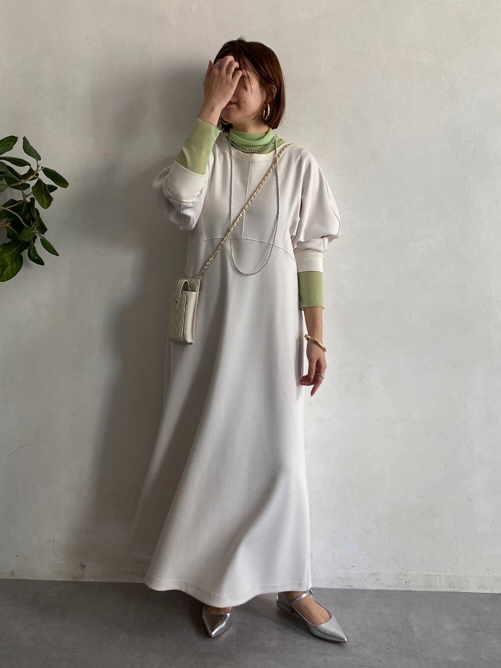グリーン系のTシャツ/カットソー、ホワイト系のショルダーバッグ、ホワイト系のワンピースを着用したレディースの冬コーディネートの6枚目の写真