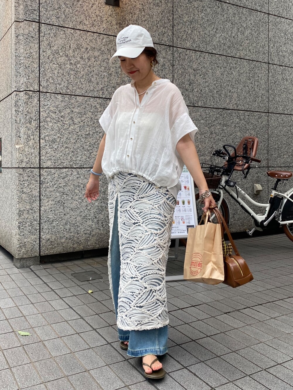 ピンク系のシャツ/ブラウス、ブルー系のデニムパンツ、ホワイト系のネックレスを着用したレディースの夏コーディネートの2枚目の写真