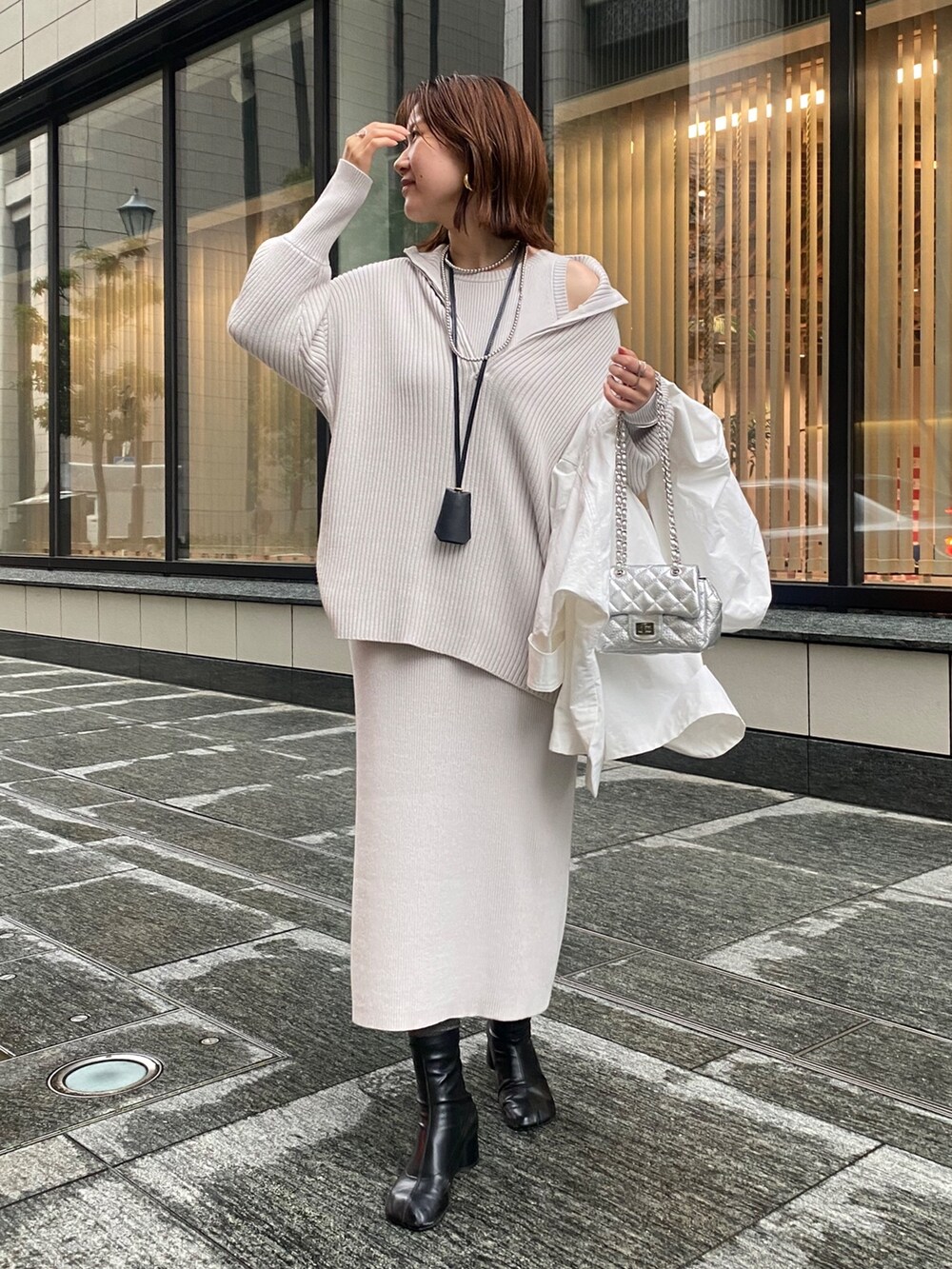 ホワイト系のブルゾン、グレー系のワンピース、シルバー系のショルダーバッグを着用したレディースの春コーディネートの4枚目の写真
