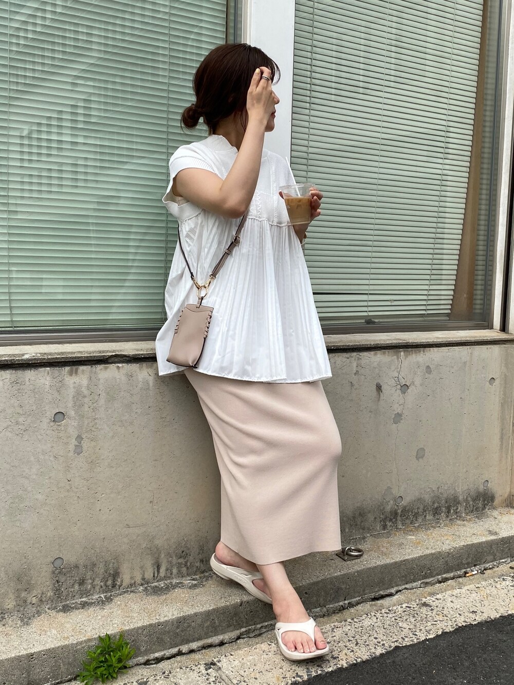 ホワイト系のニット/セーター、ベージュ系のスカート、ホワイト系のサンダルを着用したレディースの夏コーディネートの2枚目の写真