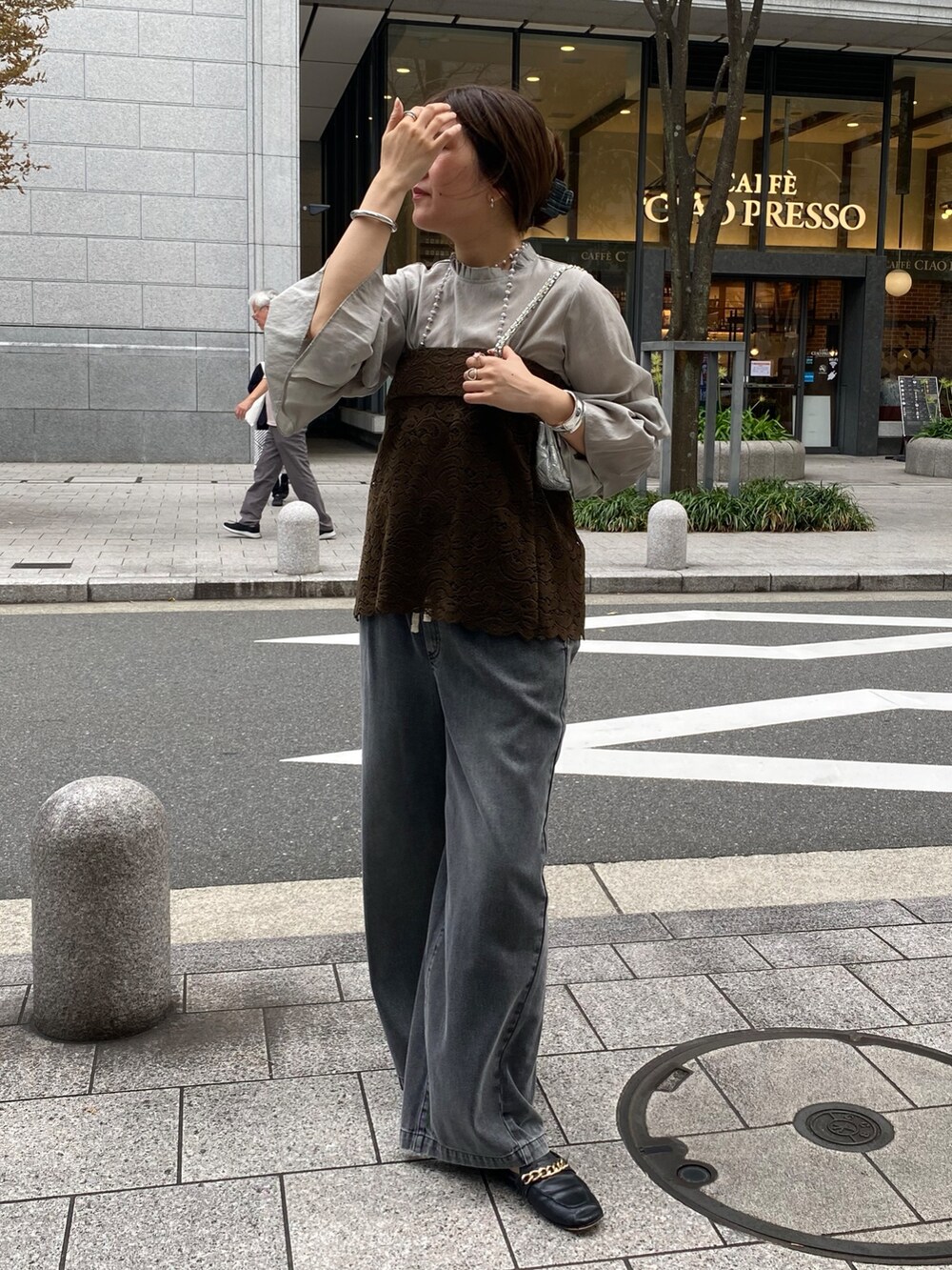 グレー系のシャツ/ブラウス、グリーン系のその他トップス、ブラック系のデニムパンツを着用したレディースの秋コーディネートの4枚目の写真