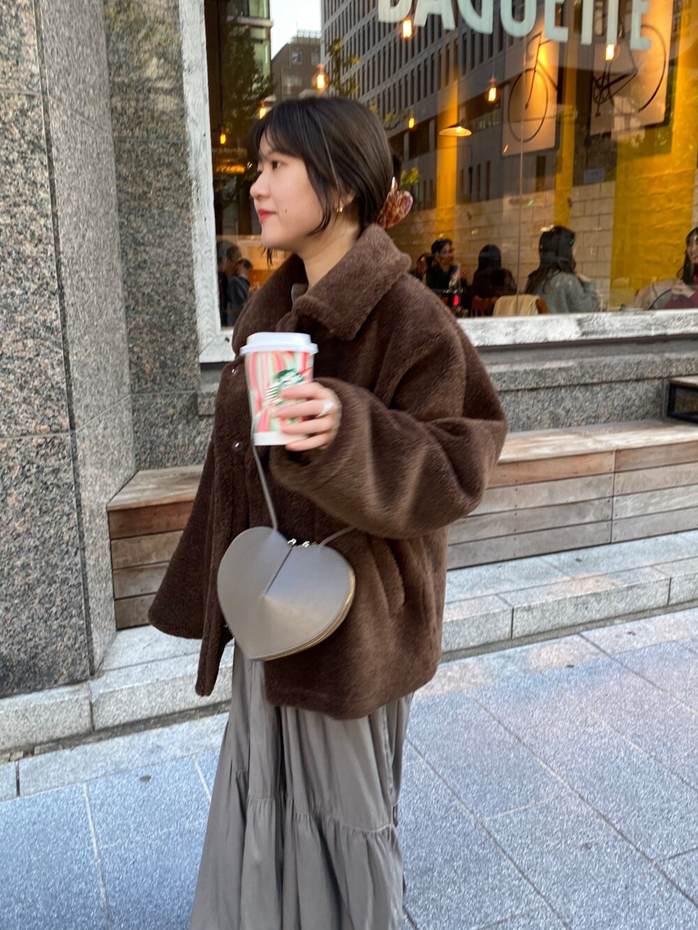 ブラウン系のその他アウター、ブラウン系のワンピース、ゴールド系のTシャツ/カットソーを着用したレディースの冬コーディネートの5枚目の写真