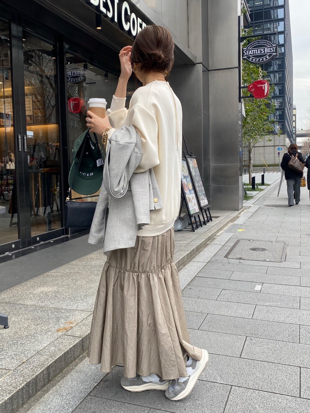 ホワイト系のワンピース、グレー系のテーラードジャケット、ゴールド系のブレスレットを着用したレディースの冬コーディネートの9枚目の写真