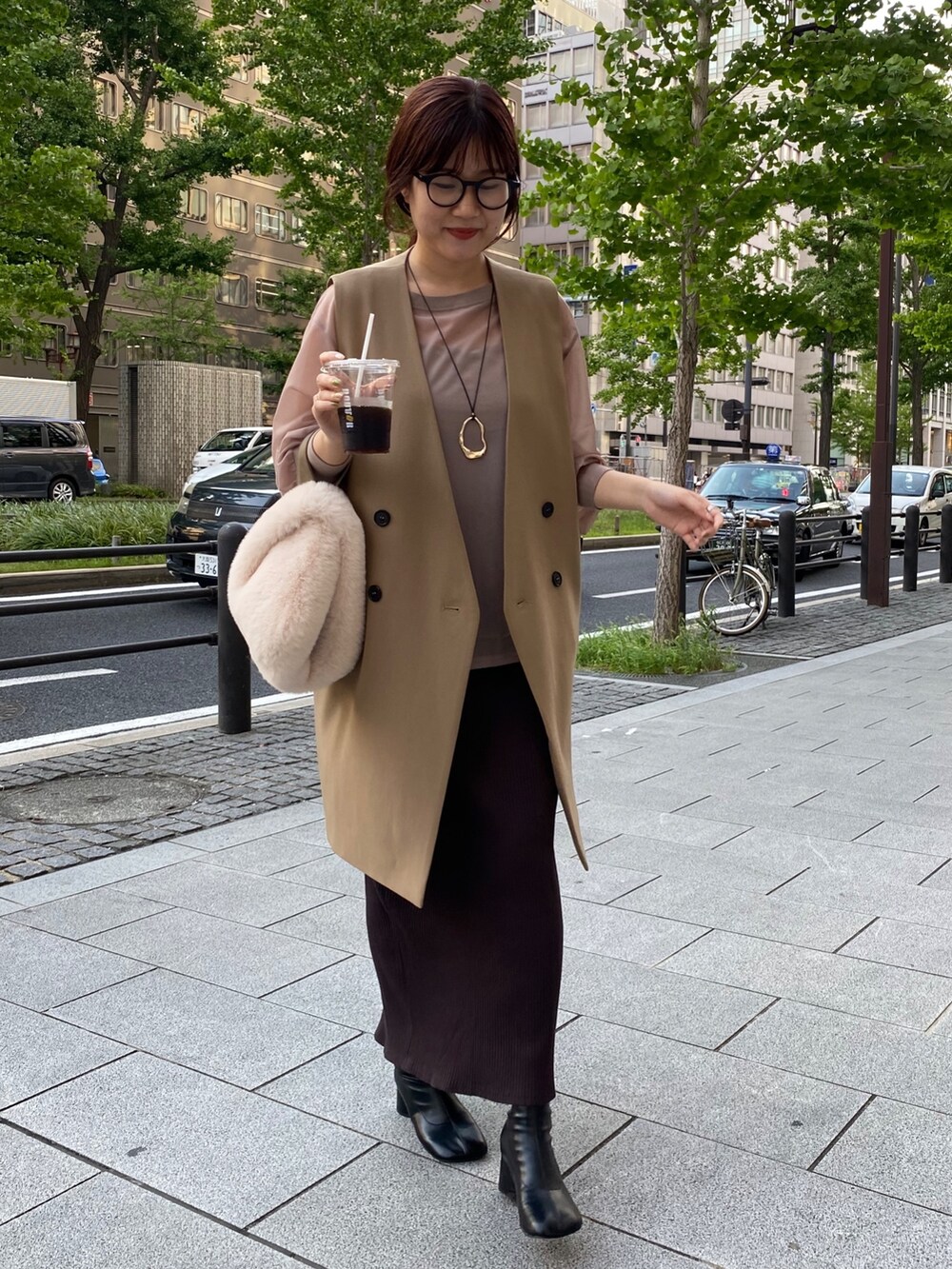 ベージュ系のワンピース、イエロー系のベストを着用したレディースの夏コーディネートの3枚目の写真