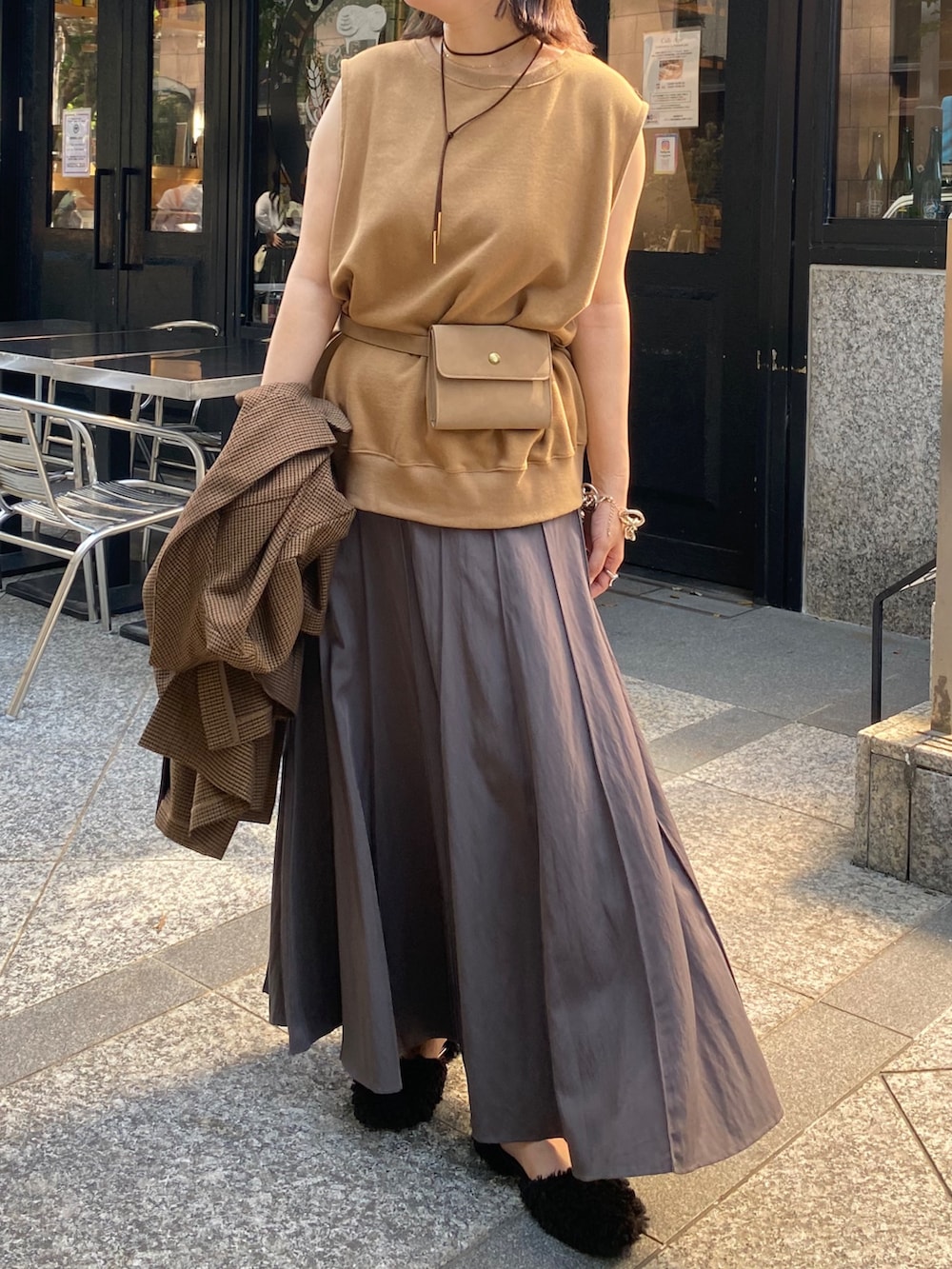 イエロー系のスウェット、グレー系のスカート、ブラウン系のテーラードジャケットを着用したレディースの夏コーディネートの3枚目の写真