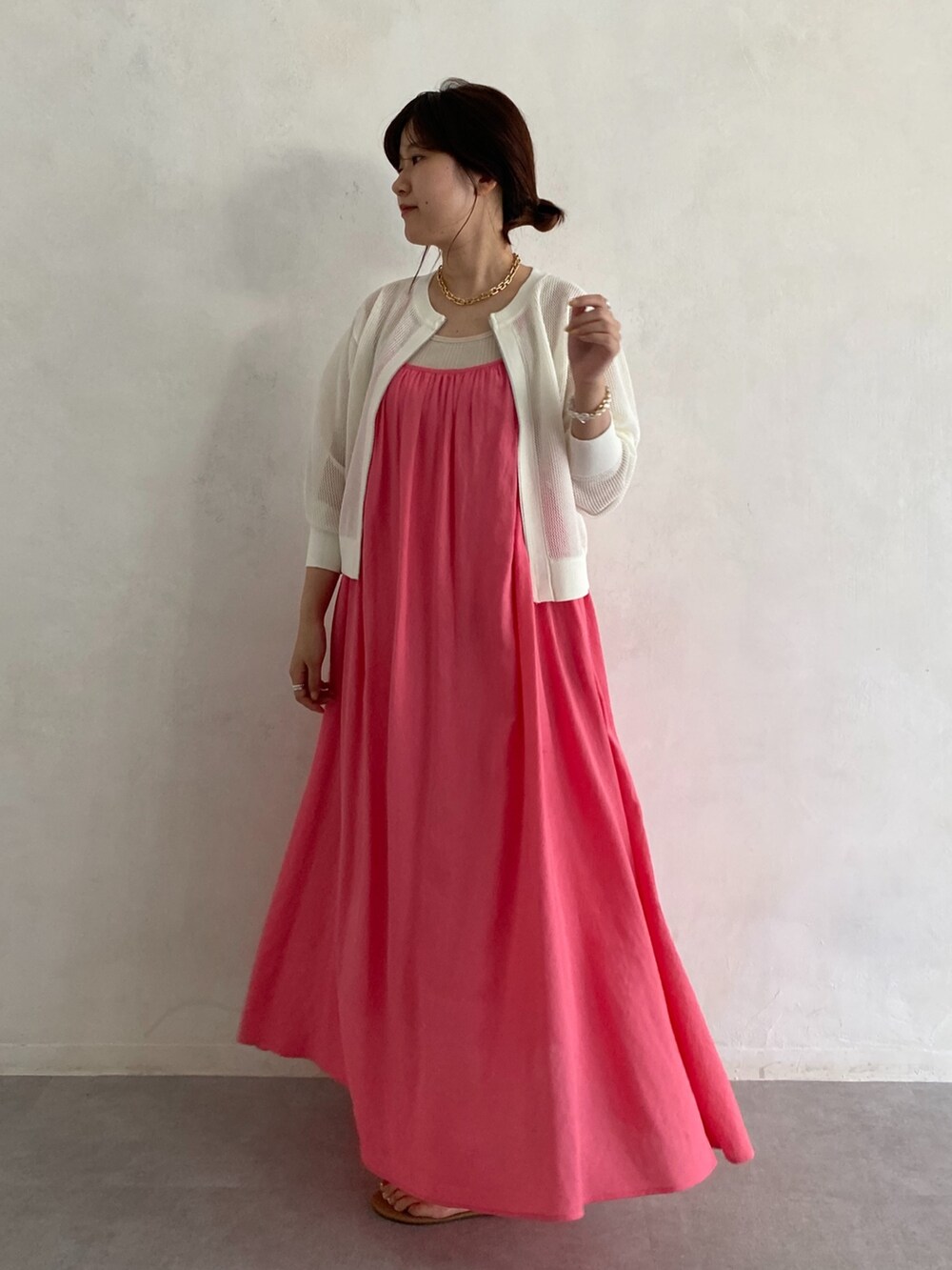 ベージュ系のカーディガン/ボレロ、ピンク系のワンピース、ゴールド系のネックレスを着用したレディースの夏コーディネートの2枚目の写真