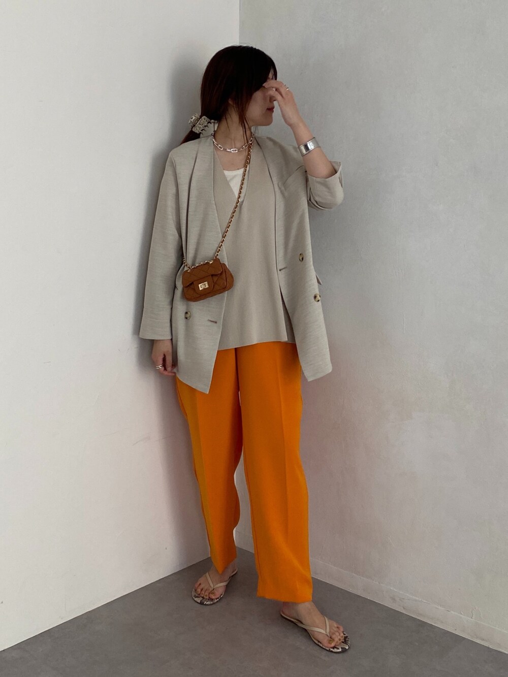 ベージュ系のノーカラージャケット、オレンジ系のその他パンツ、イエロー系のショルダーバッグを着用したレディースの夏コーディネートの2枚目の写真