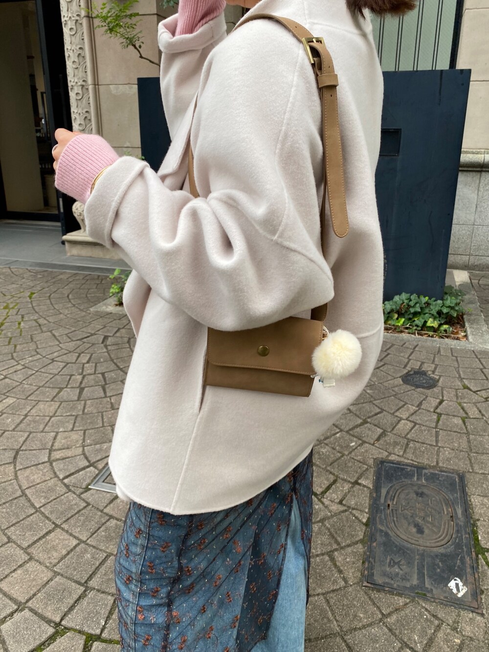 ホワイト系のその他アウター、ピンク系のニット/セーター、ブラック系のスカートを着用したレディースの冬コーディネートの9枚目の写真