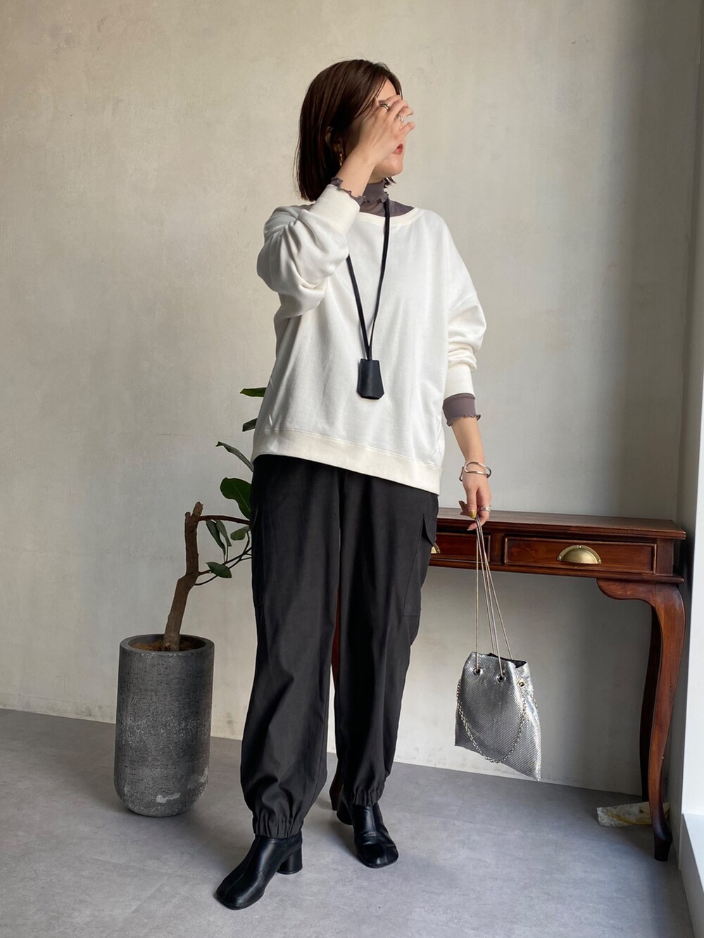 ホワイト系のTシャツ/カットソー、グレー系のTシャツ/カットソー、ブラック系のカーゴパンツを着用したレディースの冬コーディネートの2枚目の写真