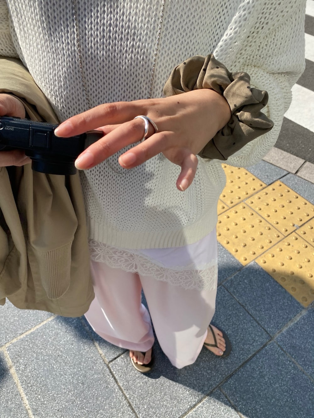 ホワイト系のTシャツ/カットソー、ピンク系のニット/セーター、ピンク系のスラックスを着用したレディースの春コーディネートの4枚目の写真