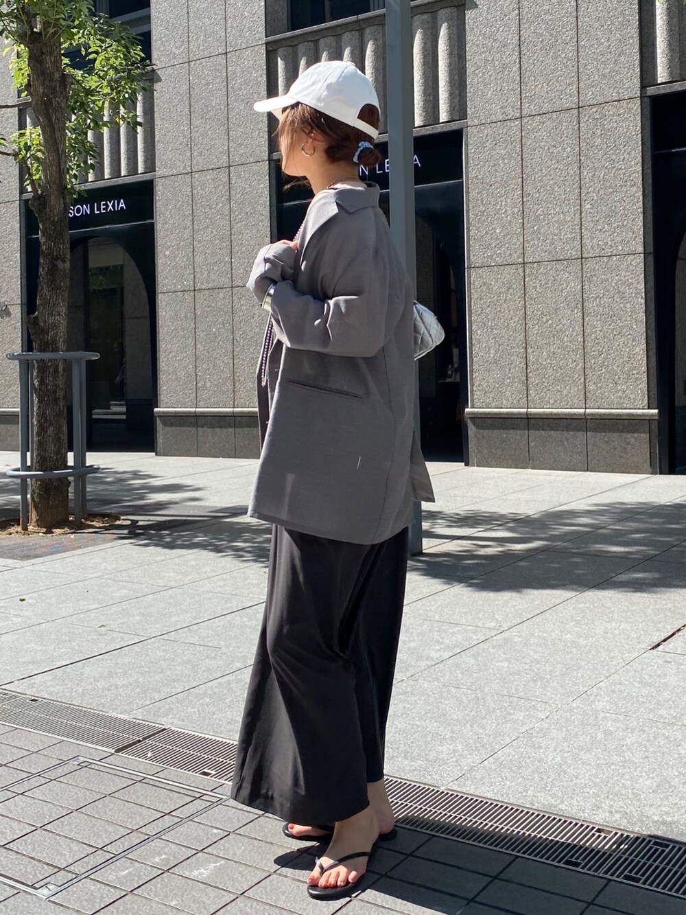 グレー系のワンピース、グレー系のテーラードジャケット、シルバー系のネックレスを着用したレディースの秋コーディネートの9枚目の写真