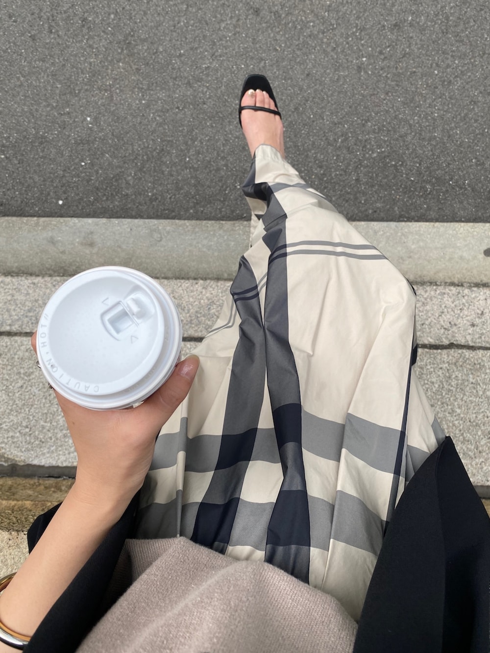 ベージュ系のニット/セーター、ベージュ系のスカート、ブラック系のサンダルを着用したレディースの冬コーディネートの3枚目の写真