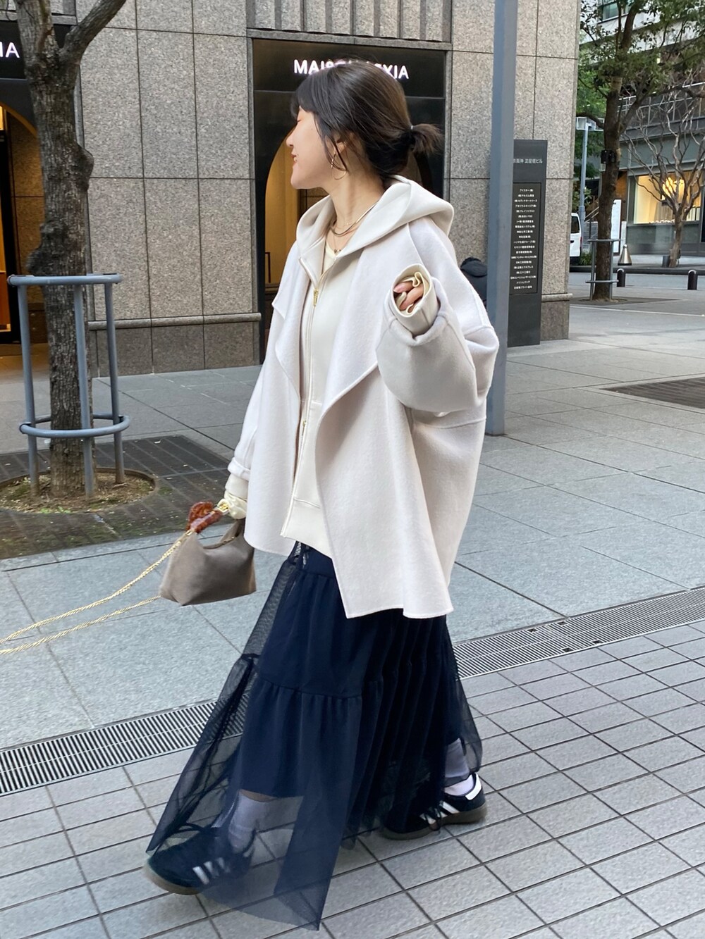 ベージュ系のTシャツ/カットソー、イエロー系のTシャツ/カットソー、ブルー系のスカートを着用したレディースの冬コーディネートの6枚目の写真