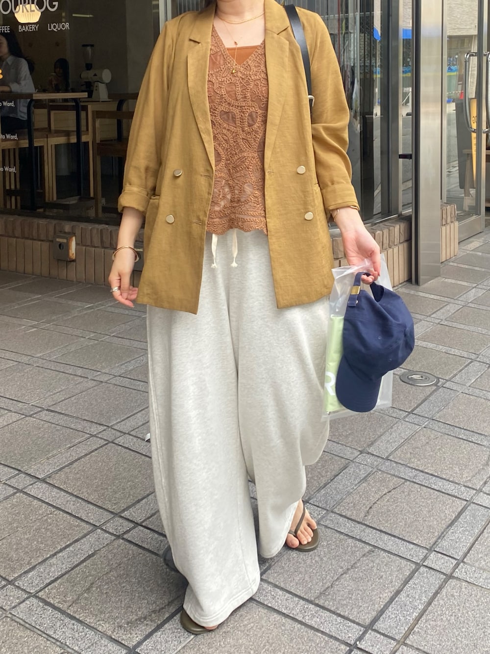 イエロー系のテーラードジャケット、イエロー系のシャツ/ブラウス、ブラウン系のタンクトップを着用したレディースの夏コーディネートの3枚目の写真