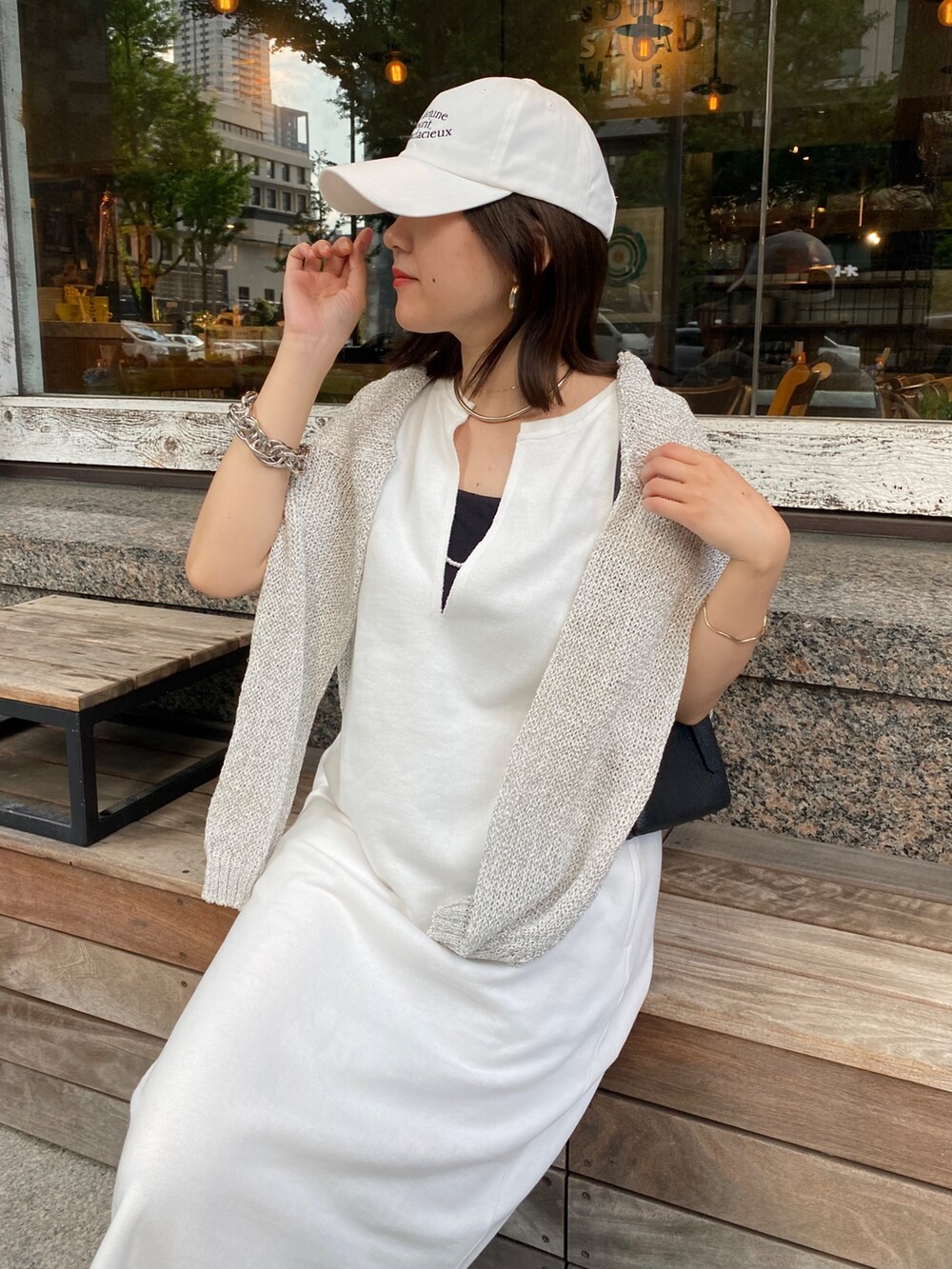 ホワイト系のワンピース、ホワイト系のキャップ、ホワイト系のネックレスを着用したレディースの夏コーディネートの4枚目の写真