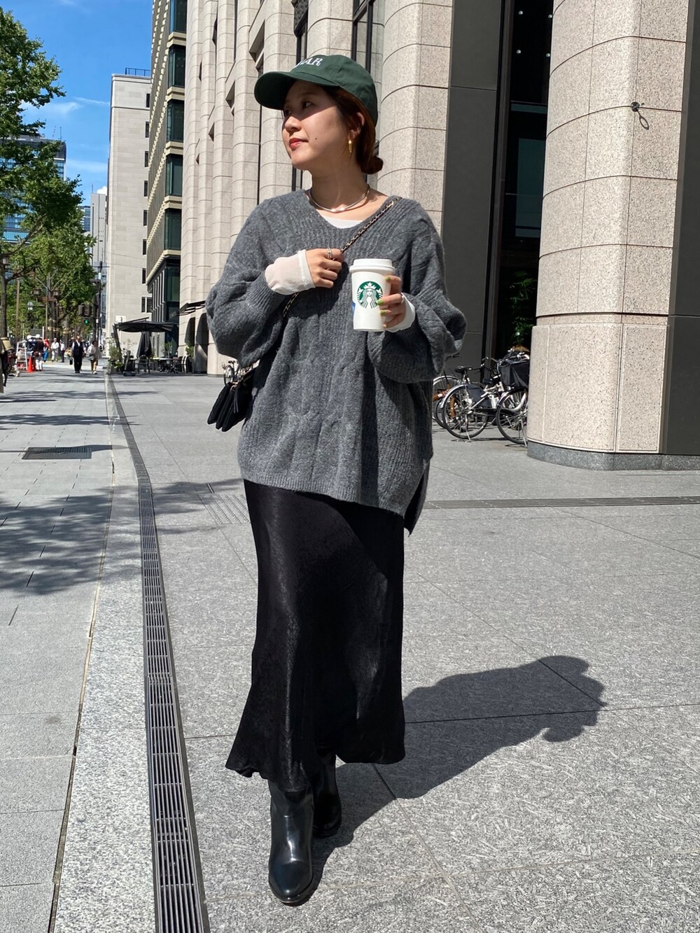 グレー系のニット/セーター、ブラック系のスカートを着用したレディースの秋コーディネートの6枚目の写真