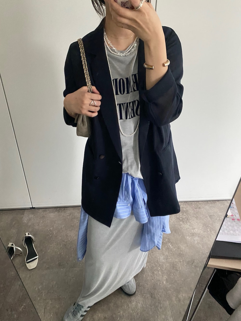 ブルー系のテーラードジャケット、グレー系のTシャツ/カットソー、グレー系のスカートを着用したレディースの春コーディネートの7枚目の写真