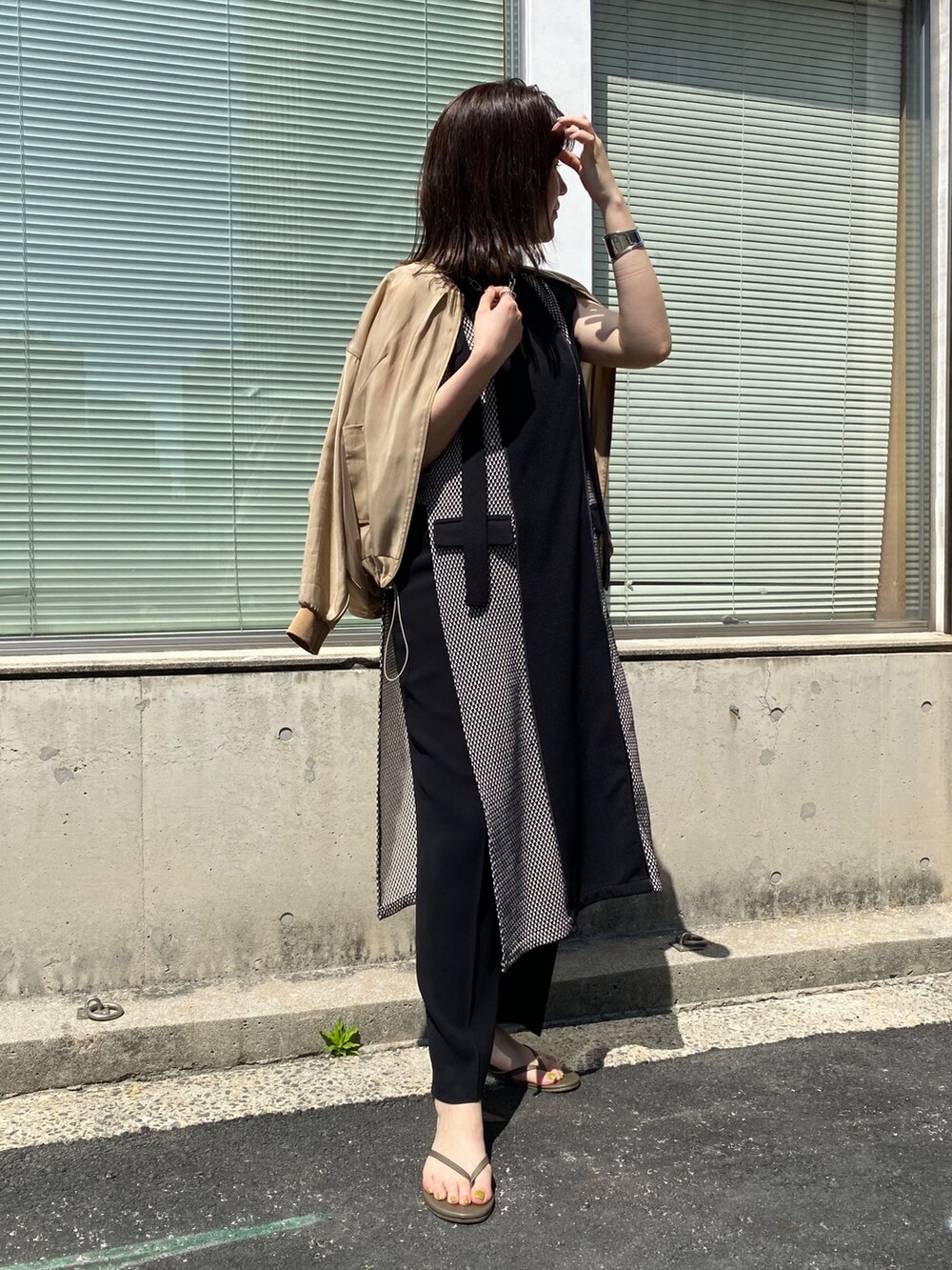 ベージュ系のブルゾン、ブラック系のワンピースを着用したレディースの夏コーディネートの3枚目の写真