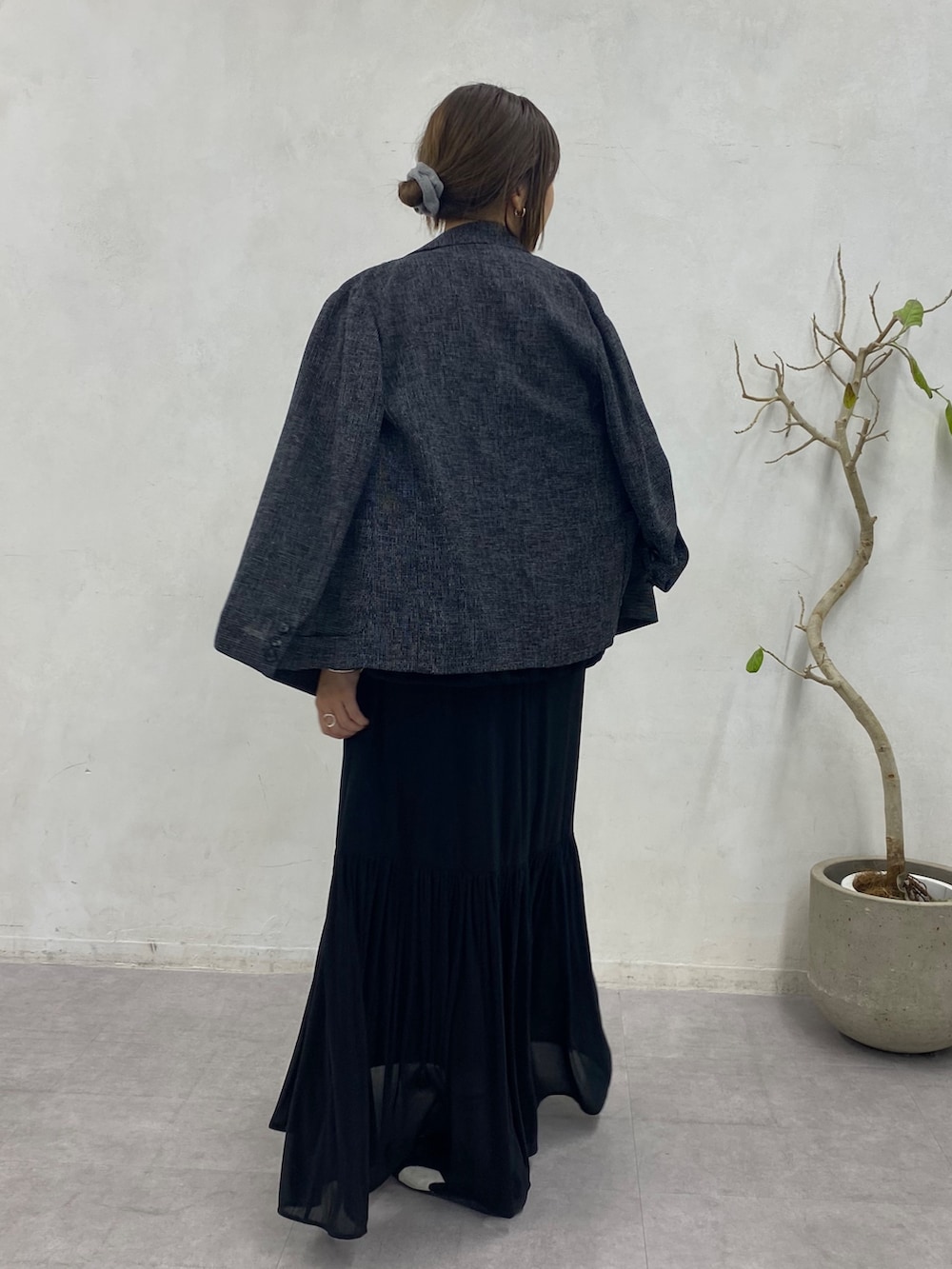 ブラック系のスウェット、ブラック系のスカート、ブラック系のテーラードジャケットを着用したレディースの冬コーディネートの5枚目の写真