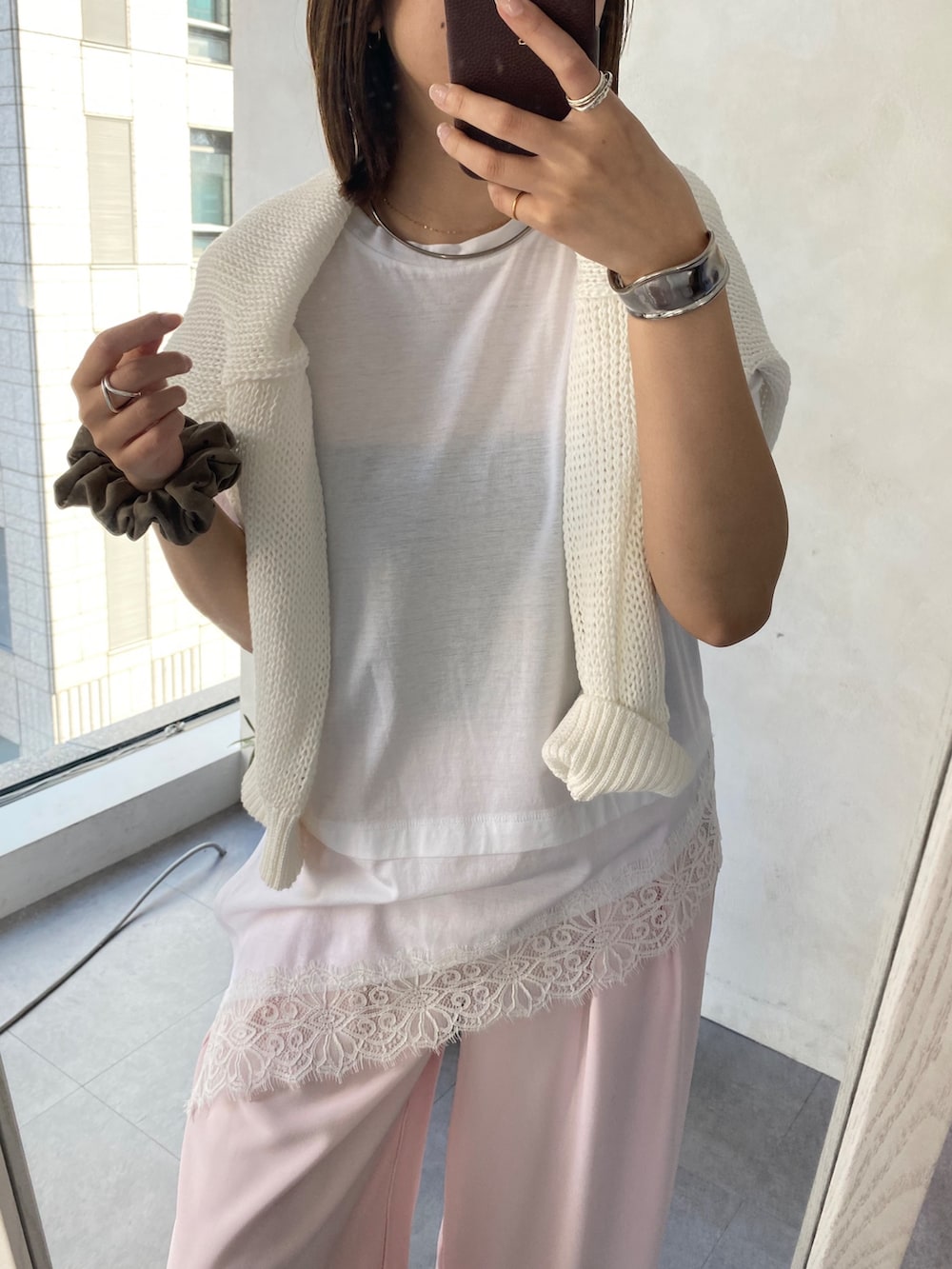 ホワイト系のTシャツ/カットソー、ピンク系のニット/セーター、ピンク系のスラックスを着用したレディースの春コーディネートの2枚目の写真