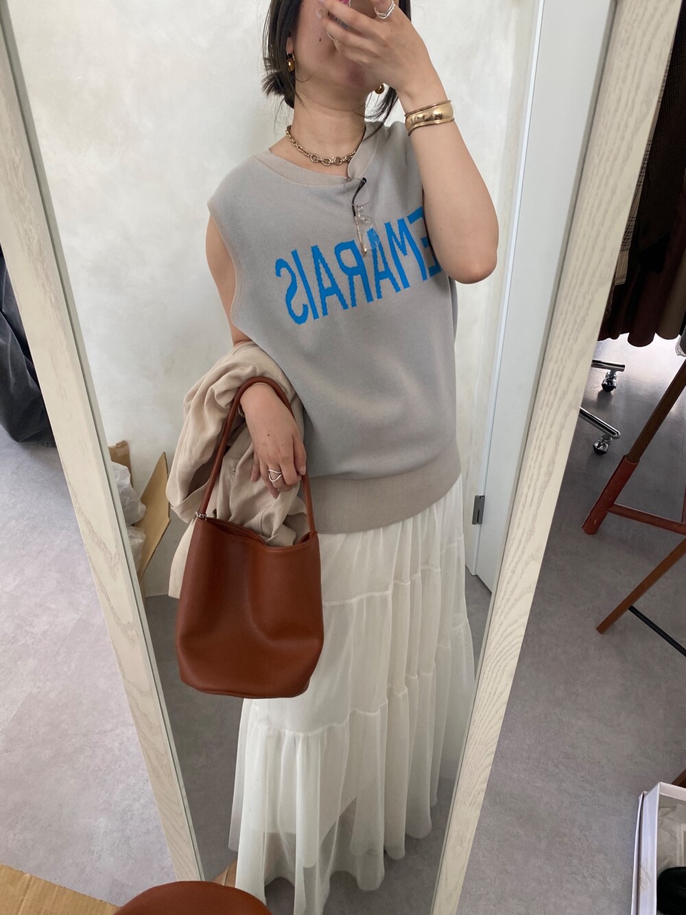 ベージュ系のテーラードジャケット、ホワイト系のスカート、ブラウン系のショルダーバッグを着用したレディースの夏コーディネートの4枚目の写真