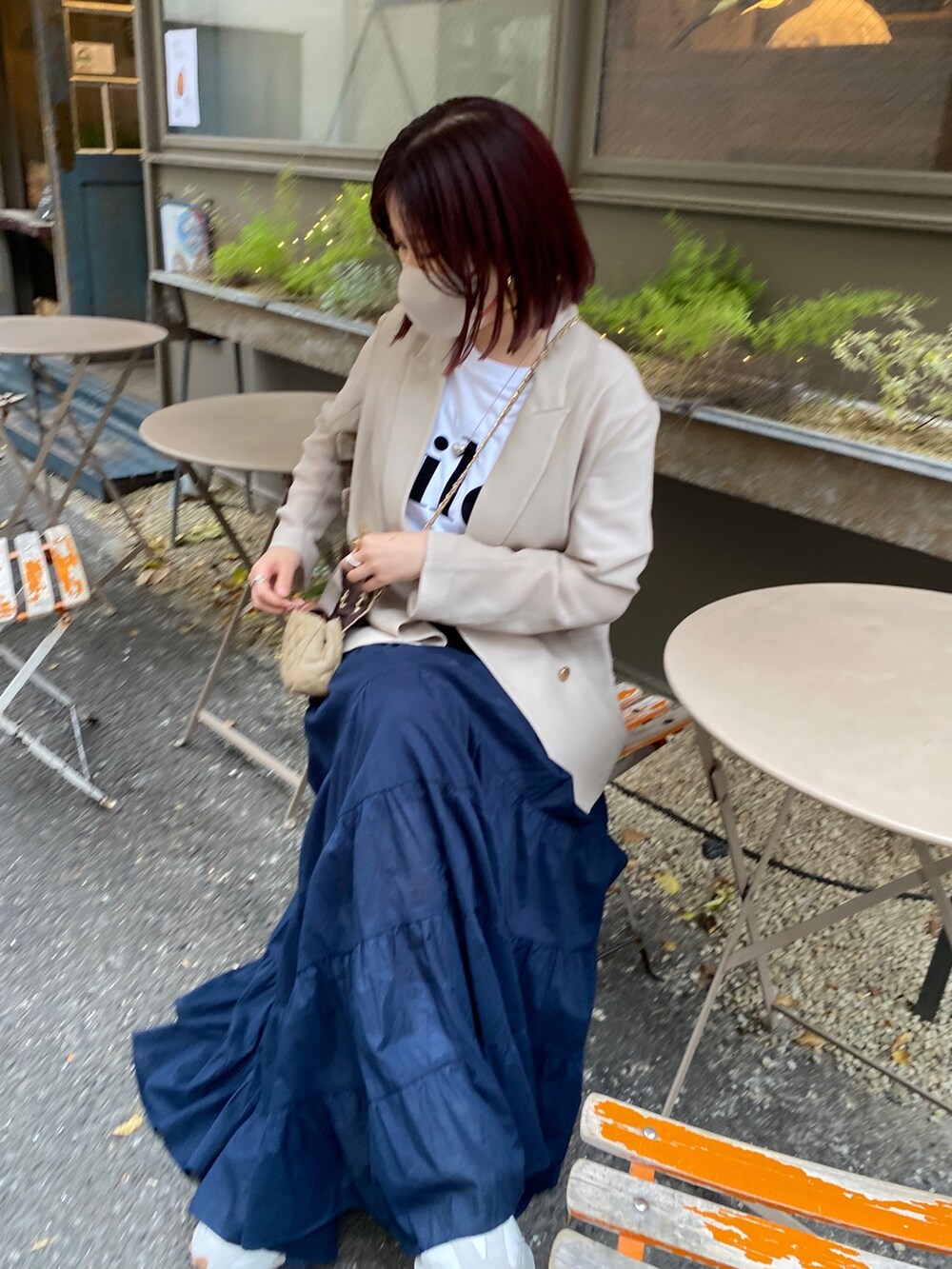 ベージュ系のテーラードジャケット、ホワイト系のTシャツ/カットソー、ブルー系のスカートを着用したレディースの春コーディネートの5枚目の写真