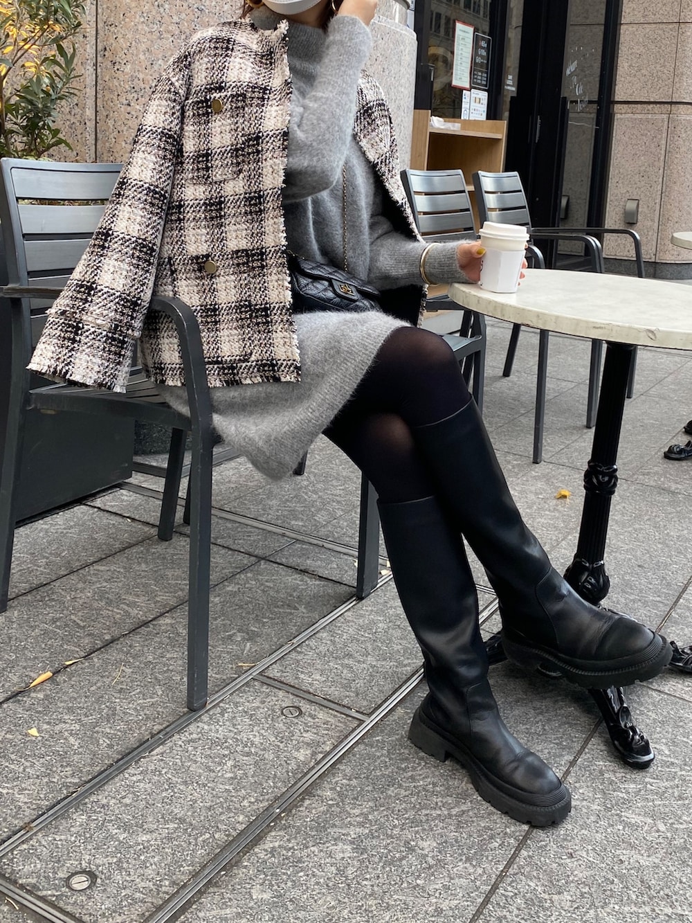 ブラック系のノーカラージャケット、グレー系のニット/セーター、ブラック系のトートバッグを着用したレディースの冬コーディネートの2枚目の写真