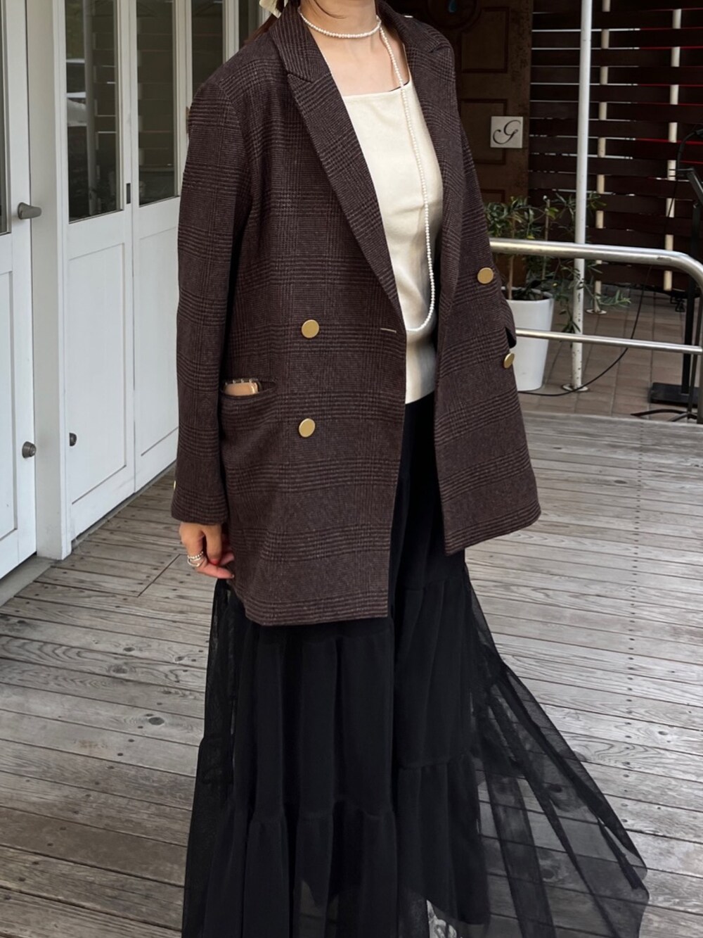 ブラウン系のテーラードジャケット、ブラック系のスカート、ブラック系のショルダーバッグを着用したレディースの秋コーディネートの8枚目の写真
