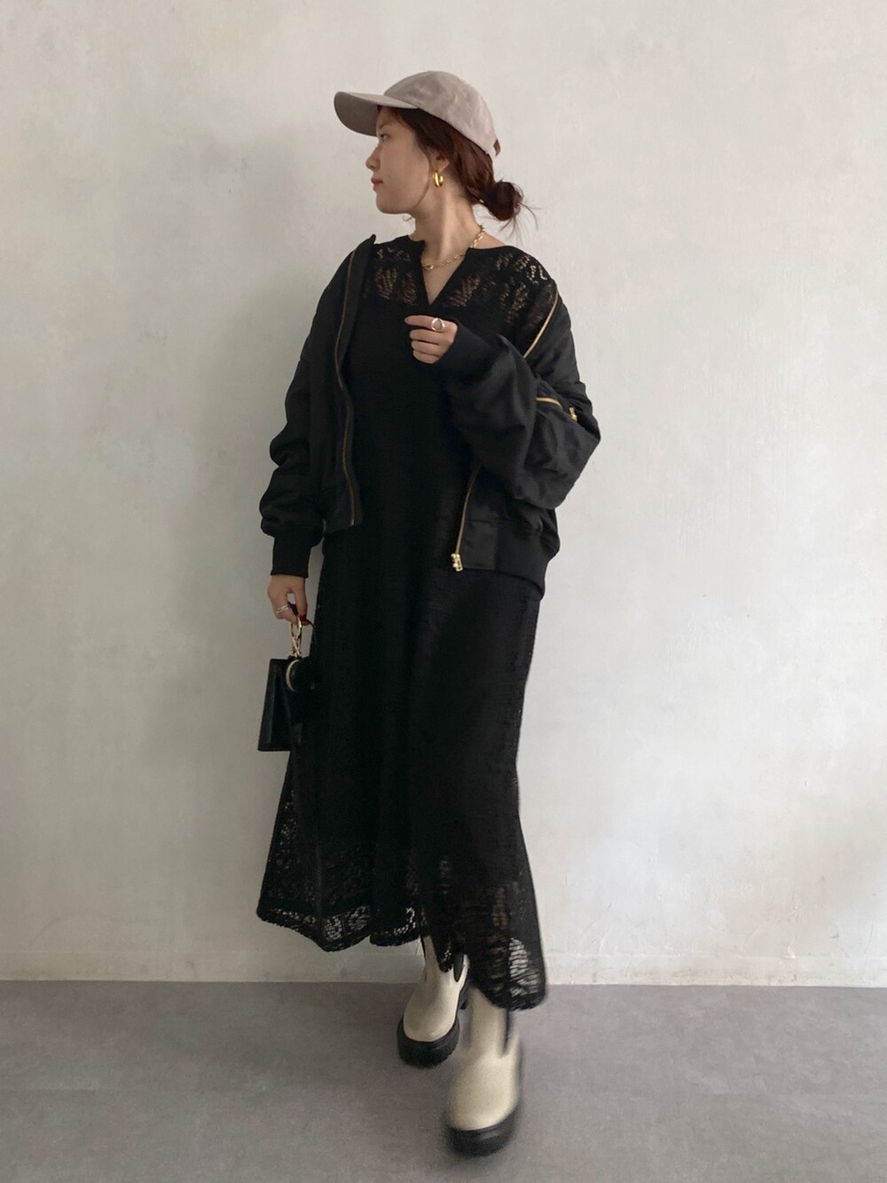 ブラック系のMA-1、ブラック系のワンピース、ホワイト系のブーツを着用したレディースの秋コーディネートの4枚目の写真