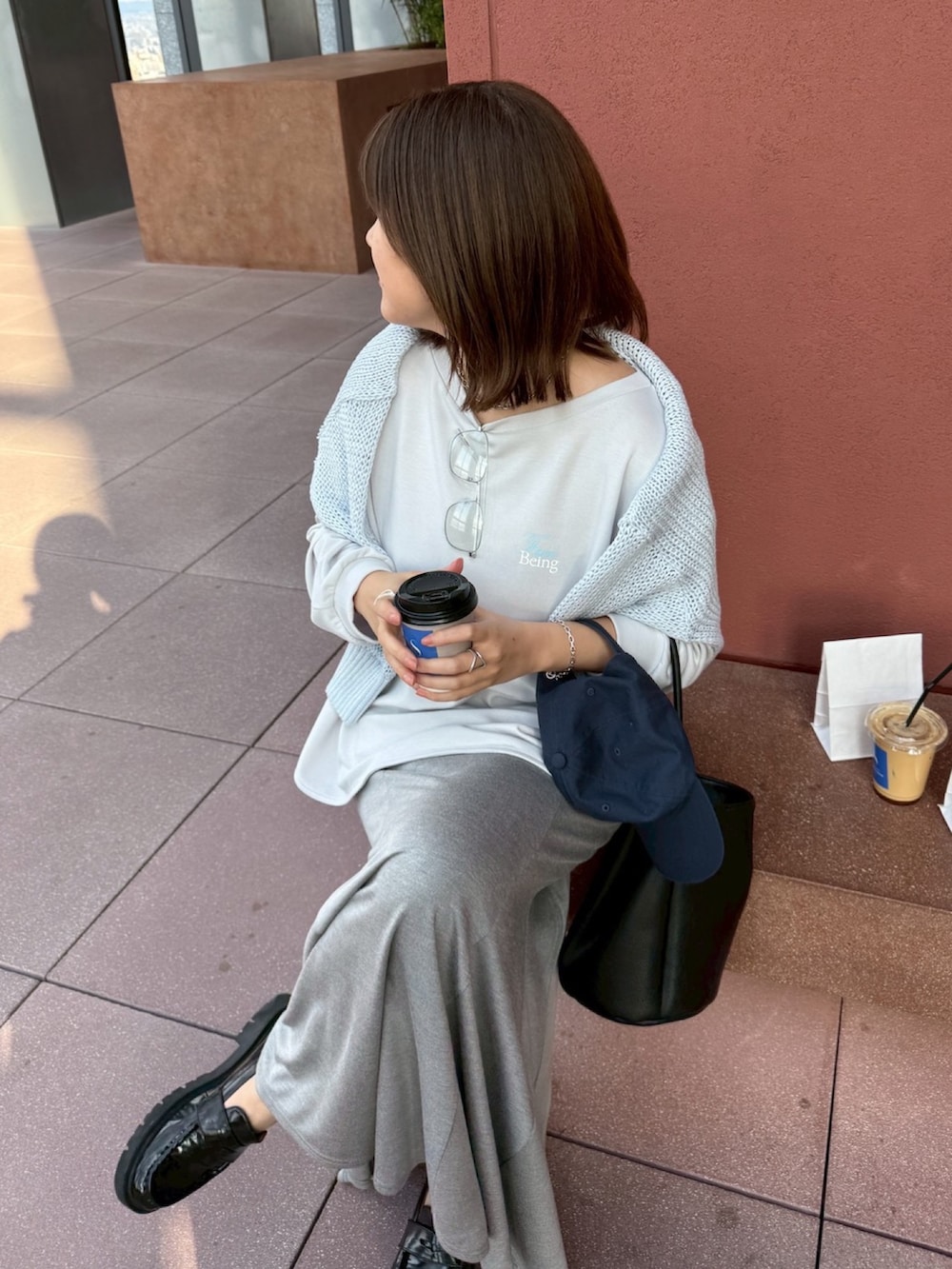 グレー系のTシャツ/カットソー、ブルー系のニット/セーター、グレー系のスカートを着用したレディースの冬コーディネートの8枚目の写真